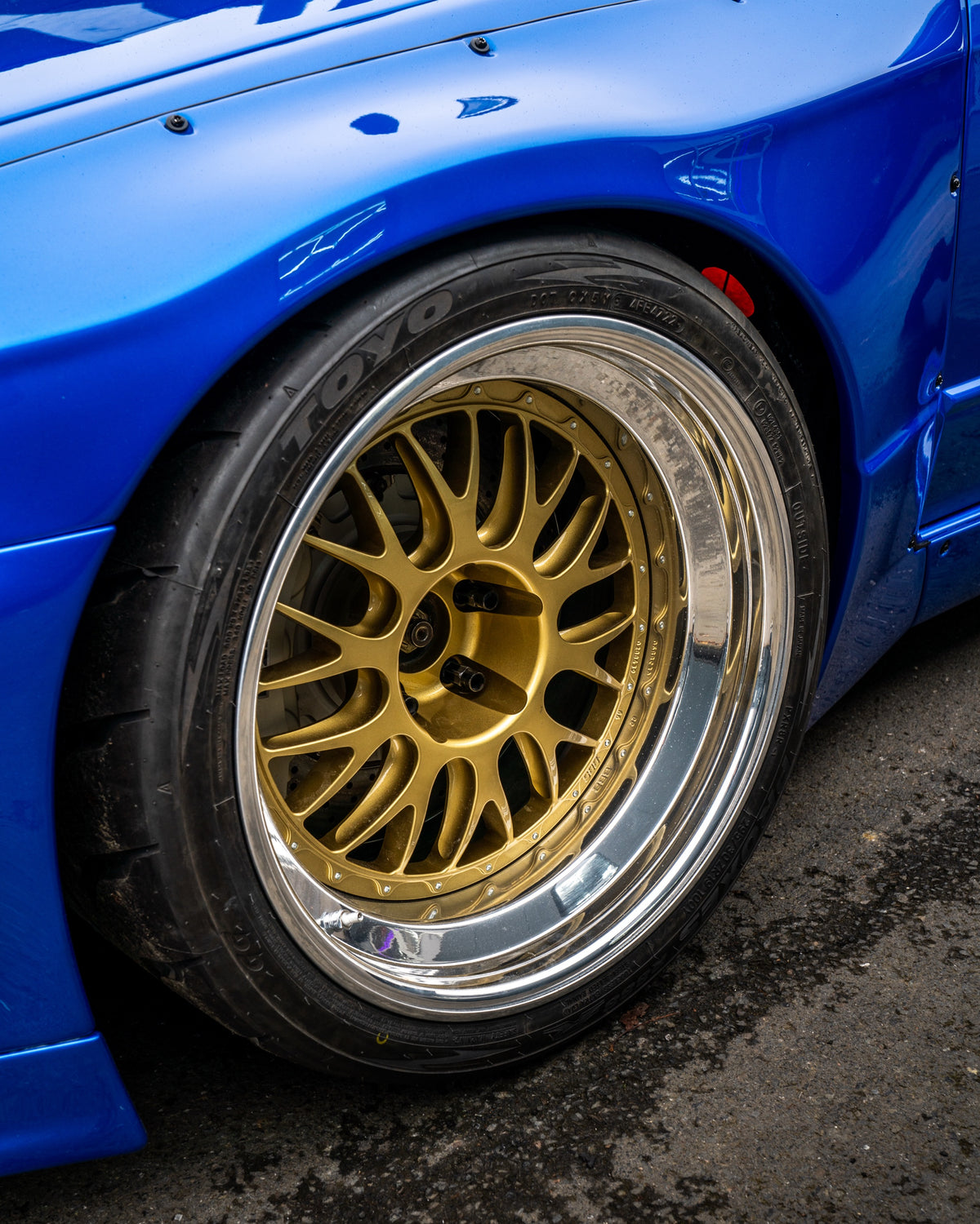 Toyo Proxes R888R on a blue widebody Nissan Skyline with gold BBS LM split-rim wheels