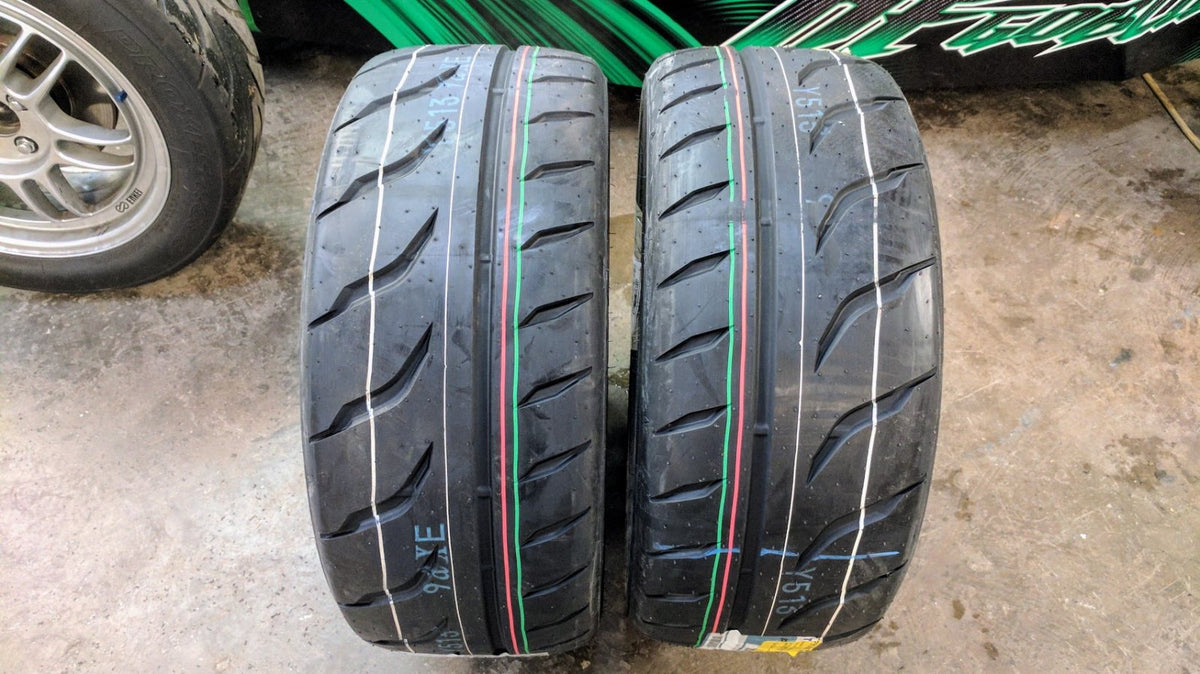 Two Toyo Proxes R888R tires side by side showing the directional tread pattern from both directions